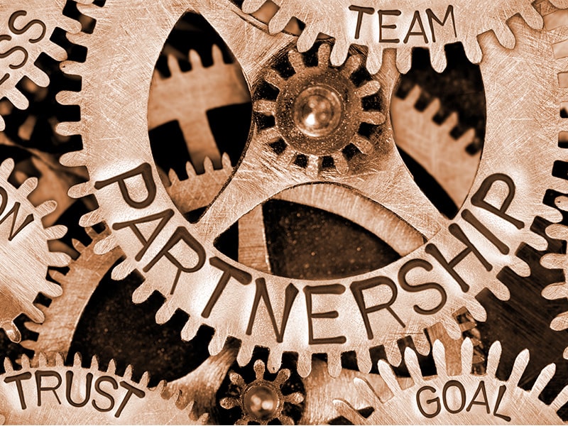 Engrenagens metálicas interconectadas com palavras como 'parceria', simbolizando a sinergia e cooperação nas estratégias de growth marketing.