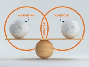 Ilustração de um balanço equilibrado com duas esferas, uma representando Marketing e outra representando Comercial, com a palavra Vendas escrita no eixo central, simbolizando a integração e equilíbrio entre as duas áreas.